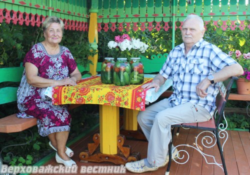 Галина Борисовна и Владимир Александрович Ершовы в беседке возле своего дома  с только что заготовленным на зиму урожаем