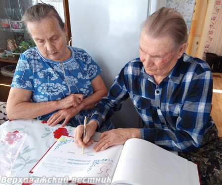 Супруги Пономаревы ставят подписи в Книге почетных юбилеев