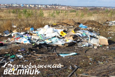 Одна из многочисленных куч мусора на берегу Ваги портит вид на деревню Сомицыно.